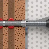 Przekrój przez materiał budowlany pokazujący kotwy chemiczne w akcji. Czerwona żywica wypełnia otwory, tworząc solidne mocowanie.