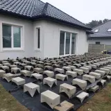 Budowa tarasu drewnianego na bloczkach betonowych. Podkład z agrowłókniny i betonowe podpory czekają na deski.