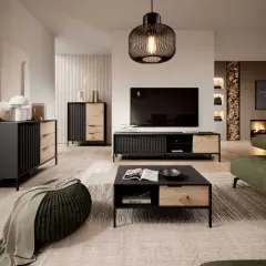 Nowoczesny salon z meblami w kolorze czarnym i **hikora naturalna**. Kominek, zielona sofa i okrągły puf tworzą przytulną atmosferę.