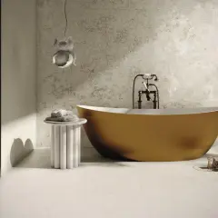 Elegancka łazienka z wolnostojącą, musztardową wanną i wzorzystą ścianą. Podłoga i ściany wykończone płytkami rektyfikowanymi.