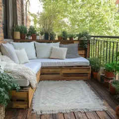 Przytulny balkon z sofą z palet, roślinami i dywanem. Idealne miejsce, by dowiedzieć się, czym osłonić balkon, tworząc zieloną oazę.