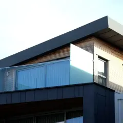 Nowoczesna architektura z drewnianymi elementami i szklanymi balustradami. Spieki materiałów tworzą ciekawy kontrast.