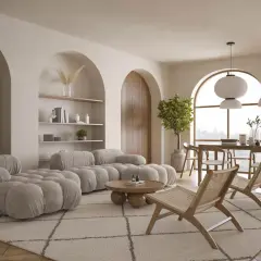 Miękka, **alabastrowa** sofa w kształcie chmur, drewniane krzesła i okrągły stolik tworzą przytulną przestrzeń.