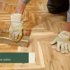 Ręce w rękawicach pracują przy parkiecie, dbając o jego klasę ścieralności.