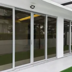 Nowoczesne drzwi tarasowe ze szkłem dymionym, odbijające zieleń ogrodu i architekturę domu.
