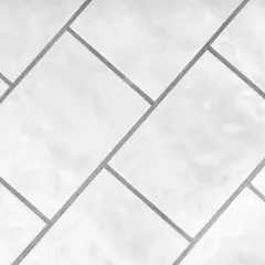 Białe, błyszczące płytki ułożone w geometryczny wzór. Precyzyjna rektyfikacja płytek zapewnia idealnie równe fugi.
