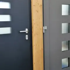 Drewniana belka między drzwiami, sugerująca jak uszczelnić próg drzwi wejściowe od spodu.
