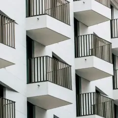 Nowoczesna fasada z wieloma balkonami, które tworzą rytmiczny wzór. To właśnie loggia, czyli wysunięty balkon, często zadaszony.