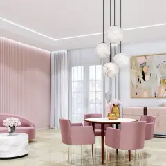 Elegancki salon w odcieniach różu z sofą, okrągłym stolikiem kawowym z blatem imitującym alabaster i krzesłami.