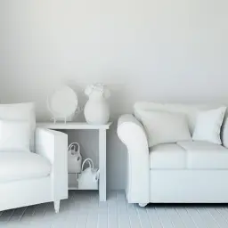 Białe fotele i sofa w odcieniu ral 9010, stolik z wazonem i dekoracjami, tworzą minimalistyczną przestrzeń.