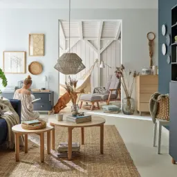 Przytulny salon z kanapą w kolorze baby blue, psem i kobietą czytającą książkę.