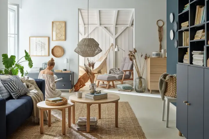 Przytulny salon z kanapą w kolorze baby blue, psem i kobietą czytającą książkę.