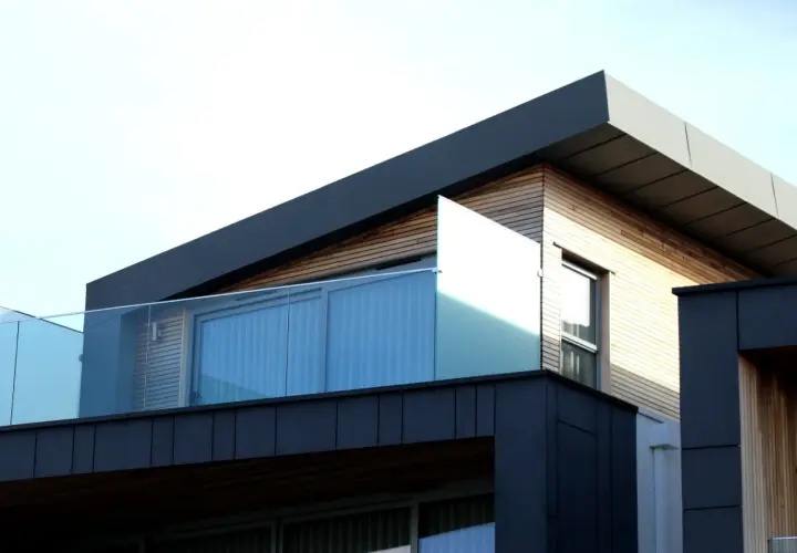 Nowoczesna architektura z drewnianymi elementami i szklanymi balustradami. Spieki materiałów tworzą ciekawy kontrast.
