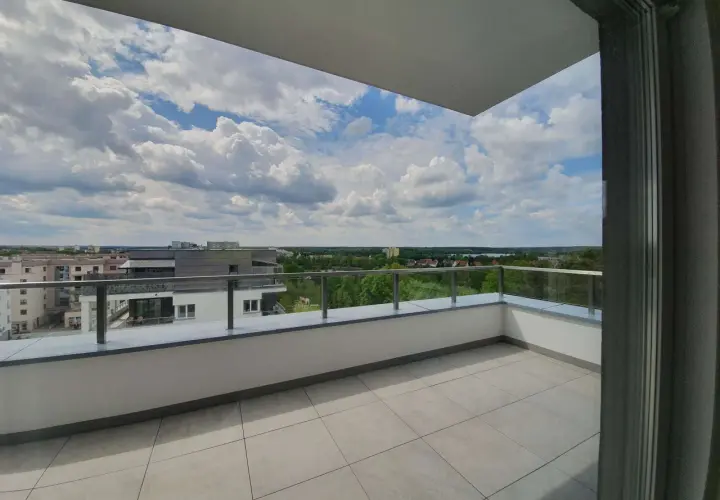 Przestronna loggia z widokiem na miasto i zieleń. Idealne miejsce na poranną kawę lub wieczorny relaks na balkonie.