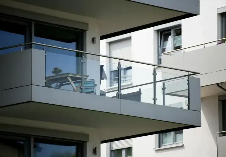 Nowoczesna loggia z przeszkloną balustradą, stolikiem i krzesłem, gotowa na poranną kawę.