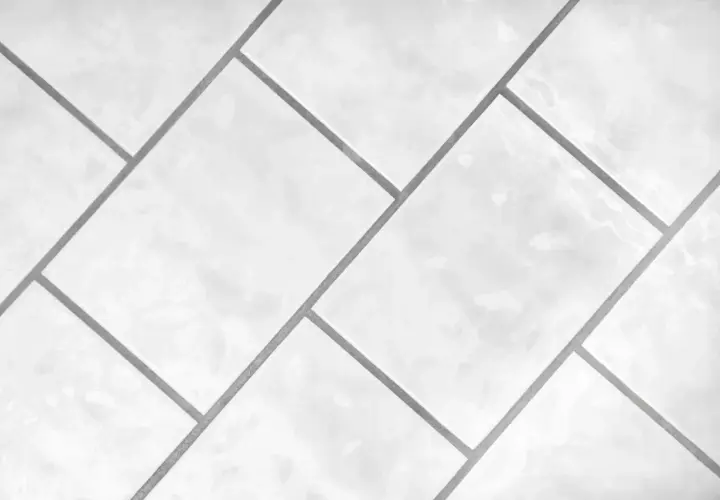 Białe, błyszczące płytki ułożone w geometryczny wzór. Precyzyjna rektyfikacja płytek zapewnia idealnie równe fugi.