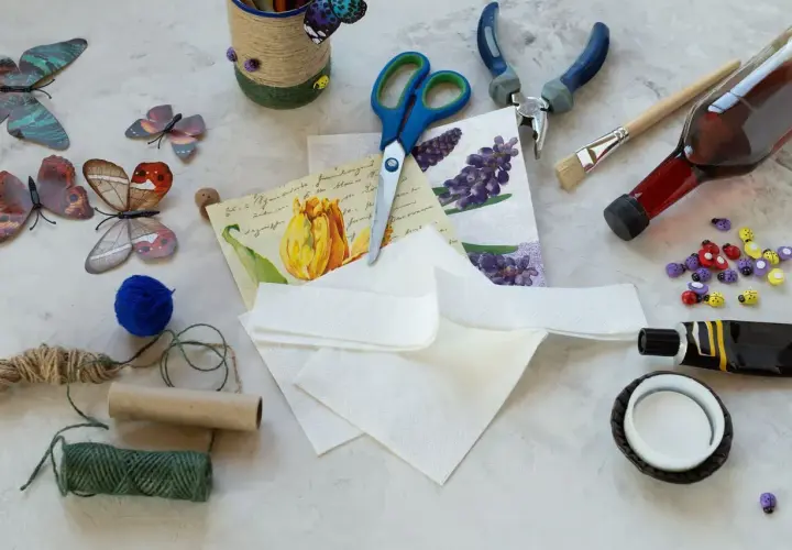 Materiały do decoupage: serwetki z motywami, nożyczki, klej, pędzel, butelka, sznurki, ozdobne biedronki.