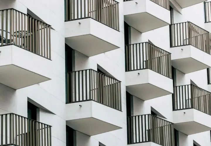Nowoczesna fasada z wieloma balkonami, które tworzą rytmiczny wzór. To właśnie loggia, czyli wysunięty balkon, często zadaszony.