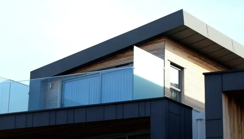 Nowoczesna architektura z drewnianymi elementami i szklanymi balustradami. Spieki materiałów tworzą ciekawy kontrast.