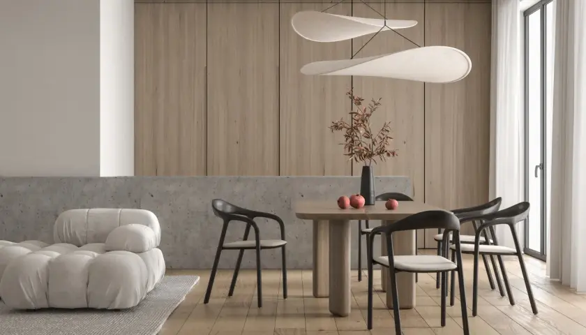 Minimalizm w domu: przytulna sofa, drewniany stół z krzesłami i dekoracje tworzą harmonię.