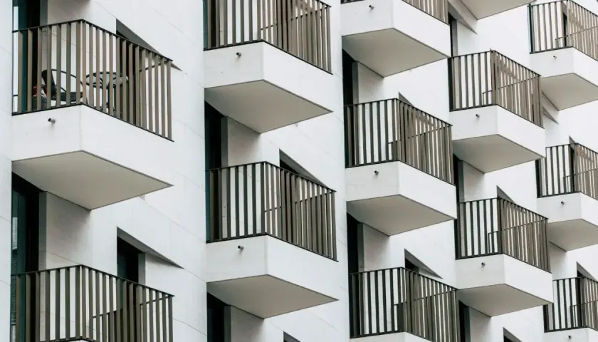 Nowoczesna fasada z wieloma balkonami, które tworzą rytmiczny wzór. To właśnie loggia, czyli wysunięty balkon, często zadaszony.