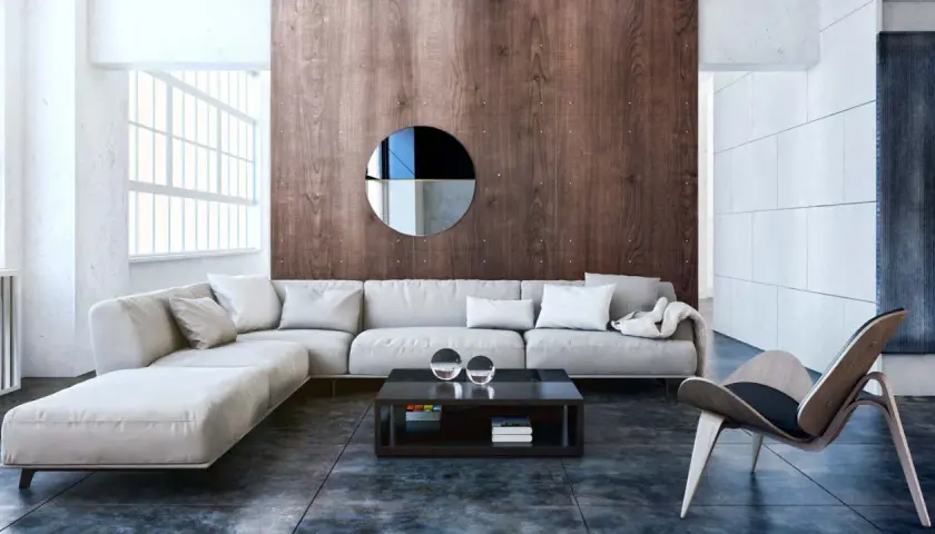 Nowoczesny salon w stylu bauhaus z wygodną, jasną sofą, drewnianą ścianą i designerskim fotelem.