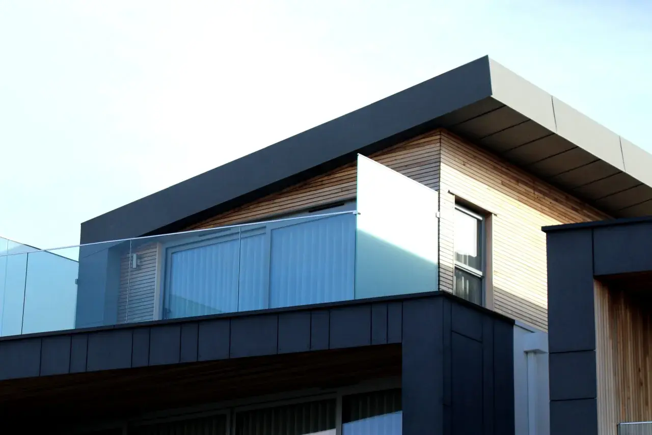 Nowoczesna architektura z drewnianymi elementami i szklanymi balustradami. Spieki materiałów tworzą ciekawy kontrast.