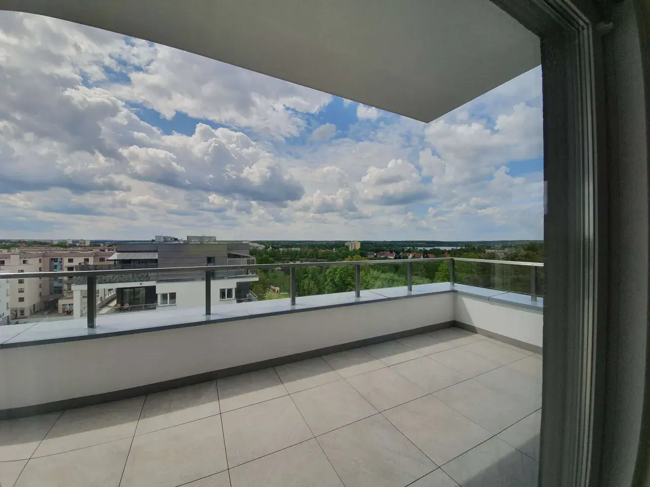 Przestronna loggia z widokiem na miasto i zieleń. Idealne miejsce na poranną kawę lub wieczorny relaks na balkonie.