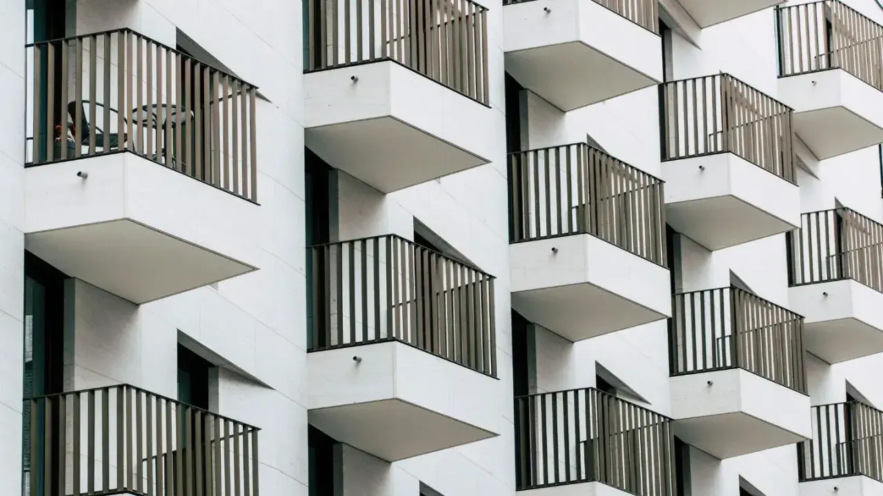 Nowoczesna fasada z wieloma balkonami, które tworzą rytmiczny wzór. To właśnie loggia, czyli wysunięty balkon, często zadaszony.