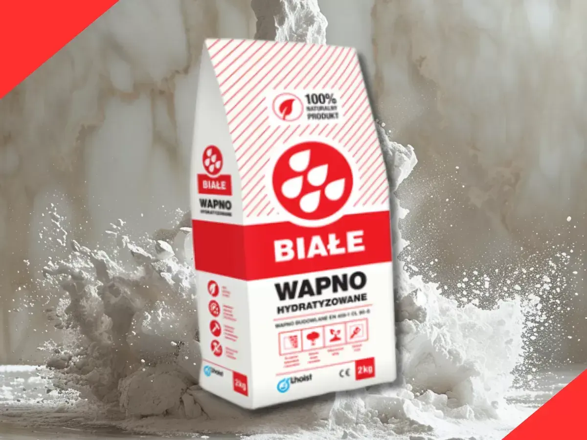 Białe wapno budowlane w worku, otoczone chmurą białego pyłu. Idealne do prac remontowych.